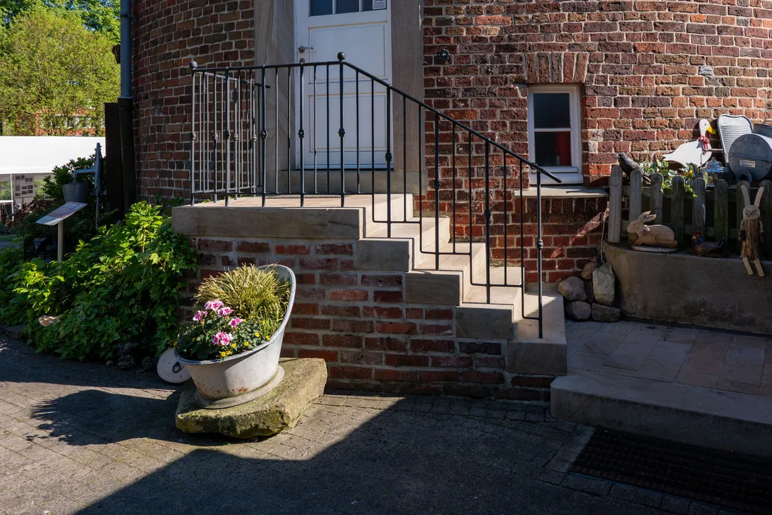 Maison en brique avec un escalier extérieur et une rampe métallique