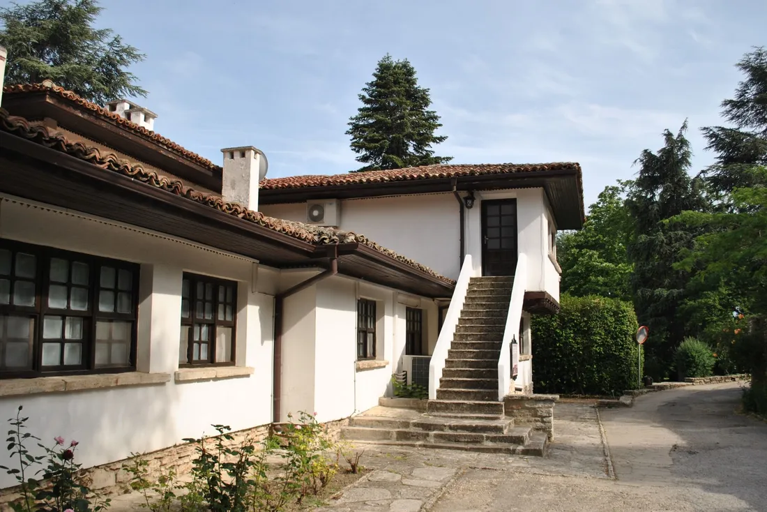 Maison blanche à toit de tuiles avec un escalier extérieur